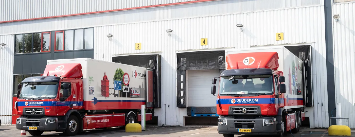 2 vrachtwagens staan te laden op een bedrijventerrein