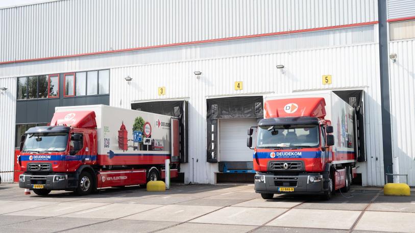 2 vrachtwagens staan te laden op een bedrijventerrein