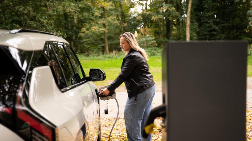 Vrouw laadt elektrische auto